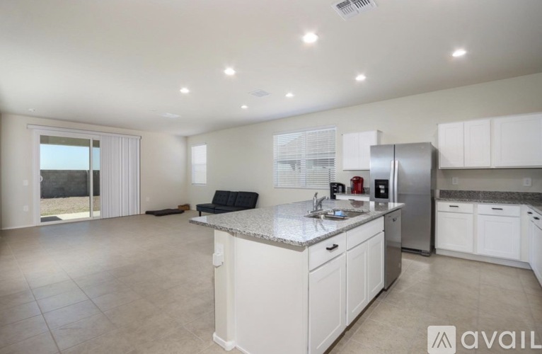 A kitchen with white cabinets and a granite countertop is available for rent.