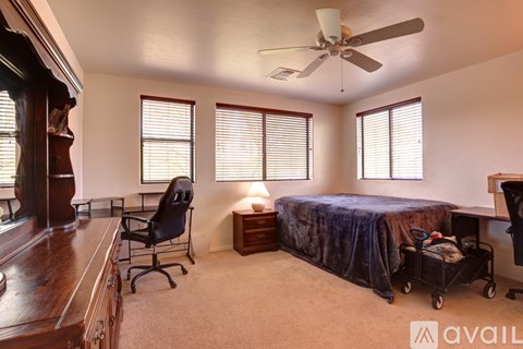 A room with a bed, a desk, and a chair.