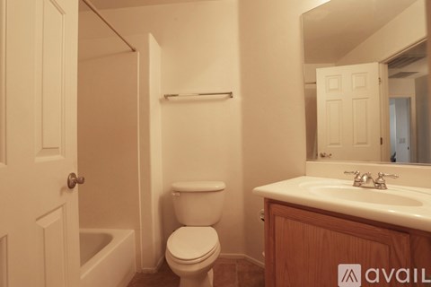 A bathroom with a toilet, sink, and bathtub.