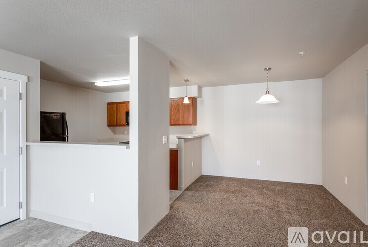 A living room with a white wall and a brown carpet.