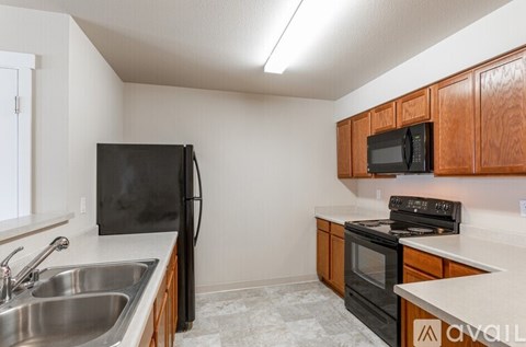 A kitchen with black appliances and wooden cabinets.