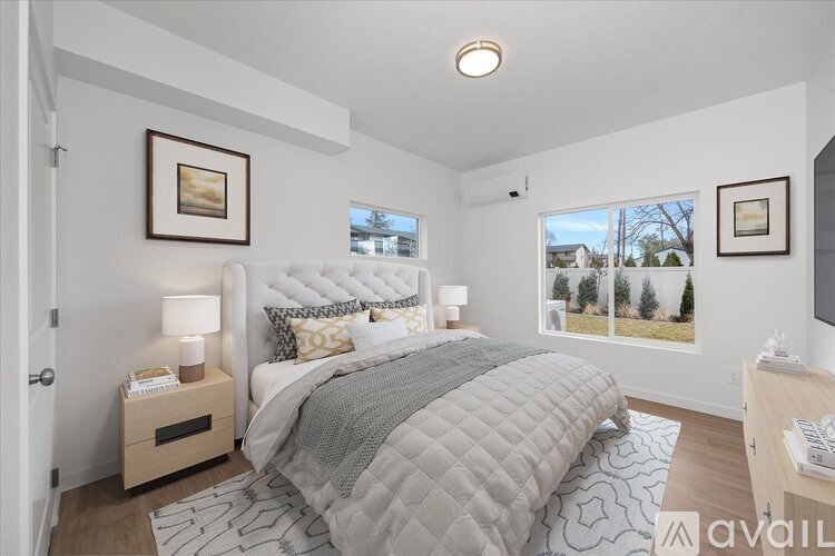 A bedroom with a large bed and a window showing trees outside.