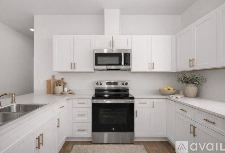 A modern kitchen with white cabinets and stainless steel appliances.