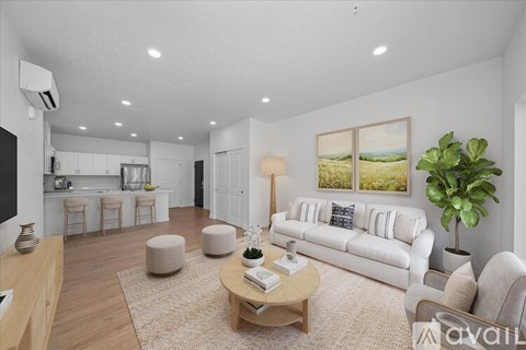 A living room with a white couch, a wooden coffee table, and a painting on the wall.