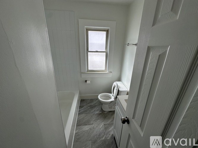 A bathroom with a toilet and a window.