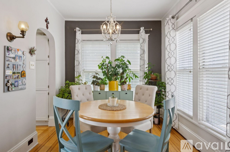 A dining room with a round table and chairs.