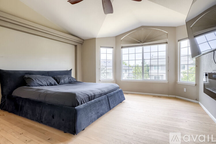 A bedroom with a large bed and a ceiling fan.