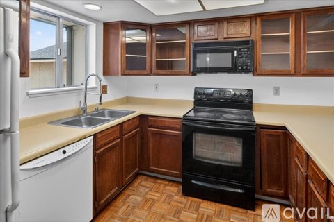A kitchen with wooden cabinets and a black oven.