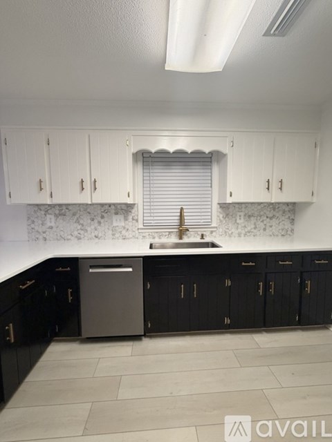 A kitchen with black cabinets and a white countertop.