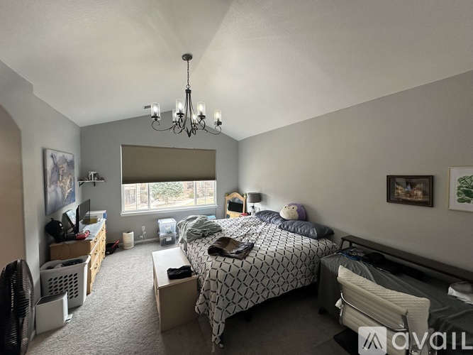 A bedroom with a large bed and a chandelier.