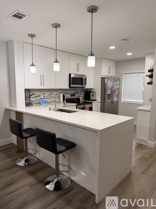 A kitchen with a bar area and a refrigerator.