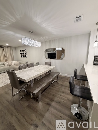 A modern dining room with a wooden table and chairs.