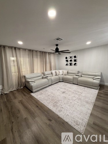 A spacious living room with a large sectional sofa and a rug on the floor.