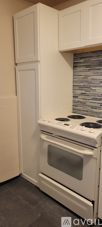 A white stove and cabinets in a kitchen.