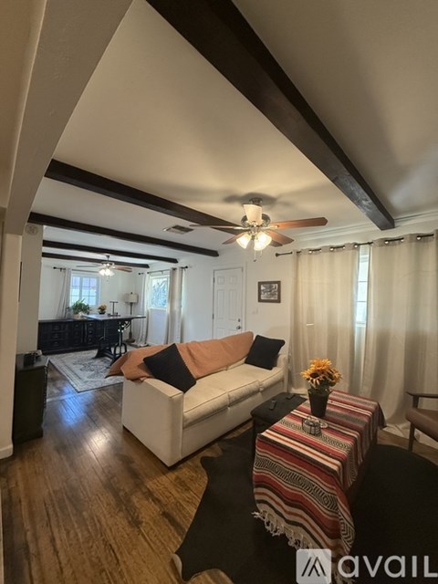 A living room with a white couch and a striped table runner.