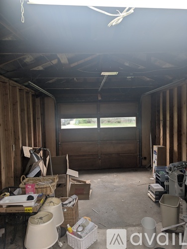 A room with wooden walls and ceiling, filled with boxes and construction materials.