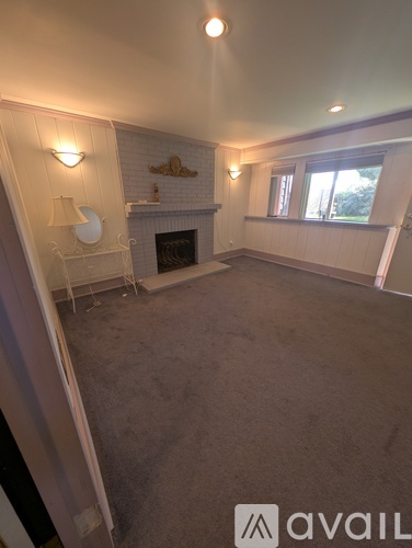 A living room with a fireplace and a window.