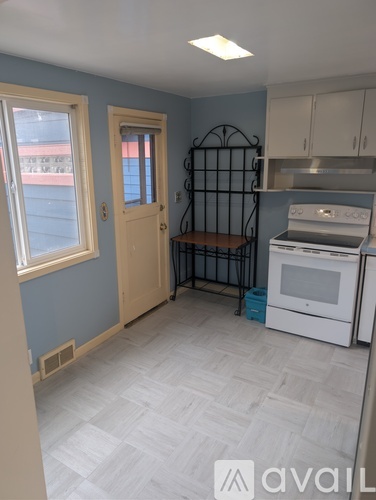 A kitchen with a white oven and a black iron gate.