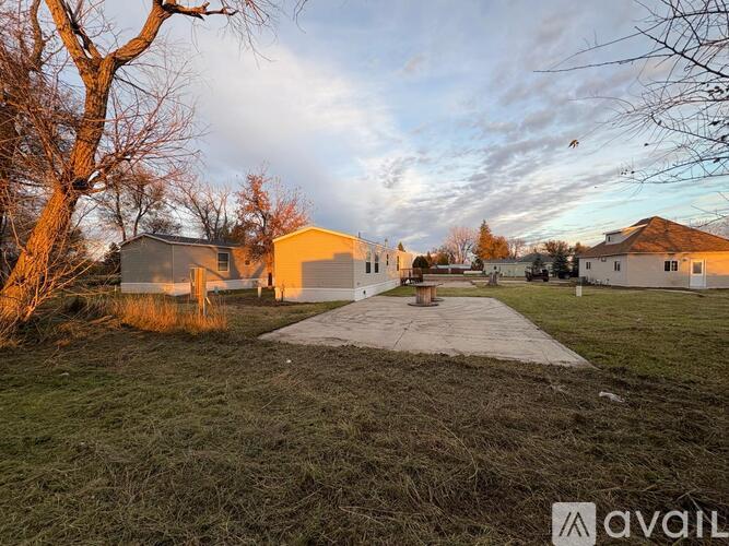 A house with a driveway and a tree in the foreground.