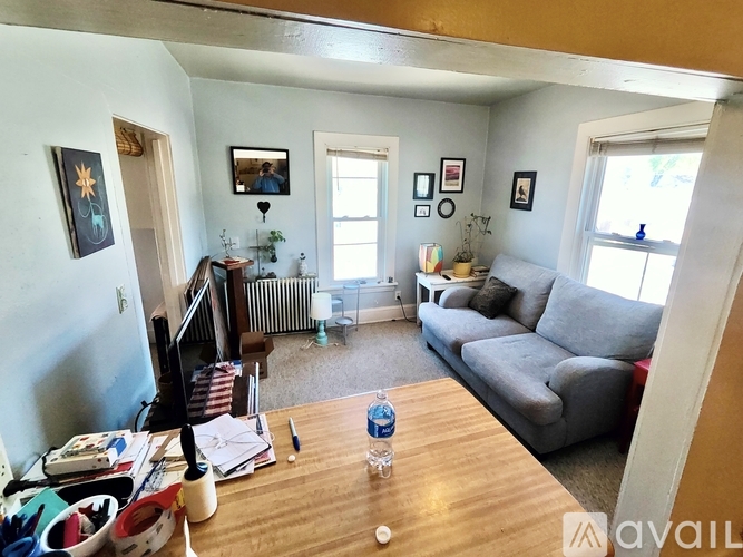 A living room with a couch, a chair, a coffee table, and pictures on the wall.