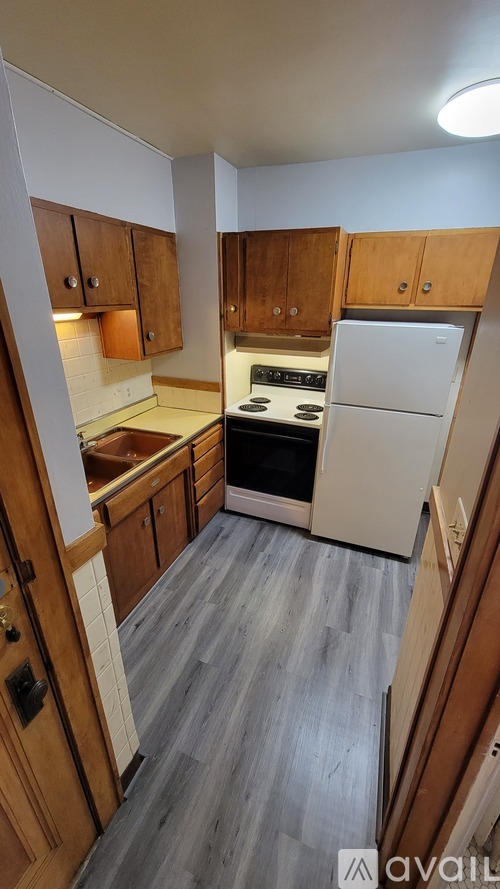 A kitchen with wooden cabinets and a white refrigerator.