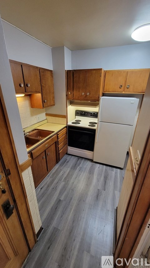 A kitchen with wooden cabinets and a white refrigerator.