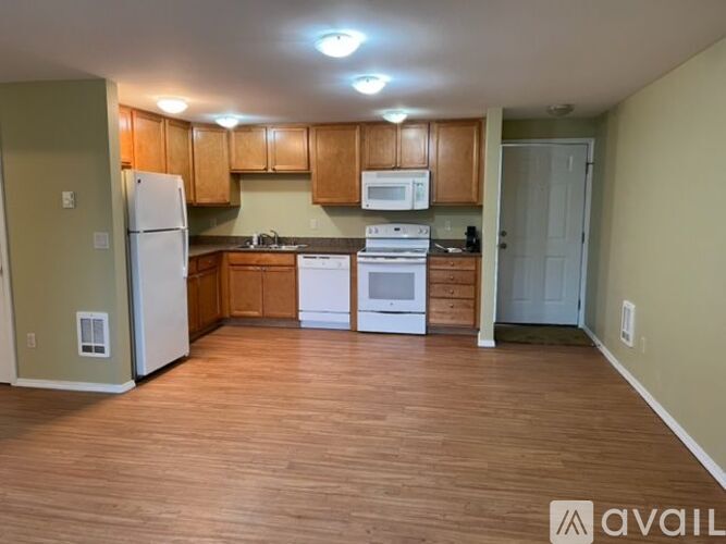 A kitchen with wooden cabinets and a white refrigerator.