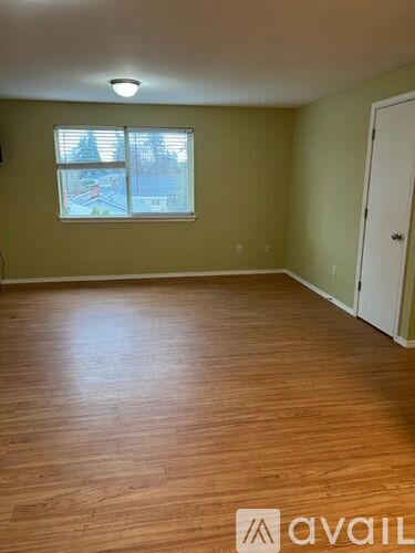 A room with wooden flooring and a window.