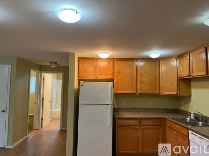 A kitchen with wooden cabinets and a white refrigerator.