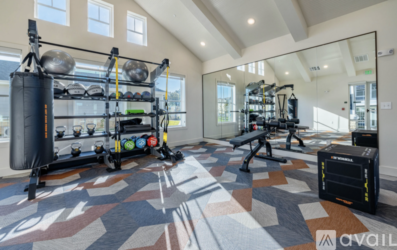 A gym with a variety of equipment including a punching bag, weight rack, and bench.