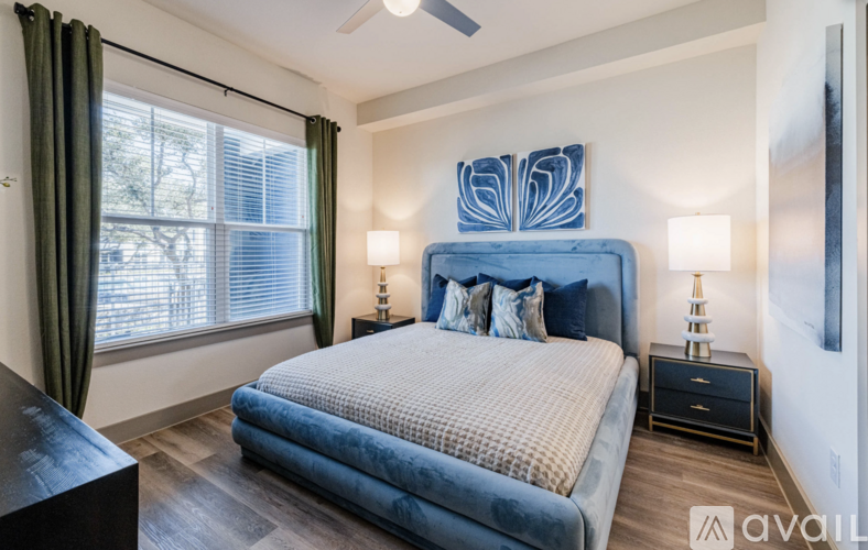 A bedroom with a large bed and a ceiling fan.