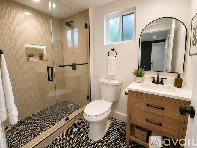 A bathroom with a toilet, sink, mirror, and shower.