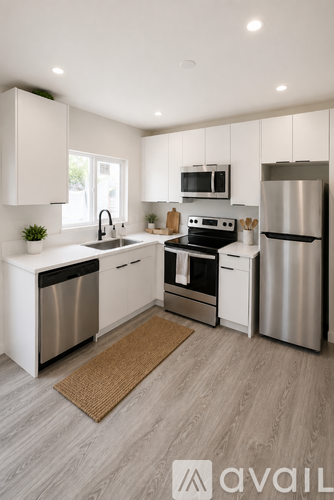 A modern kitchen with stainless steel appliances and white cabinetry.