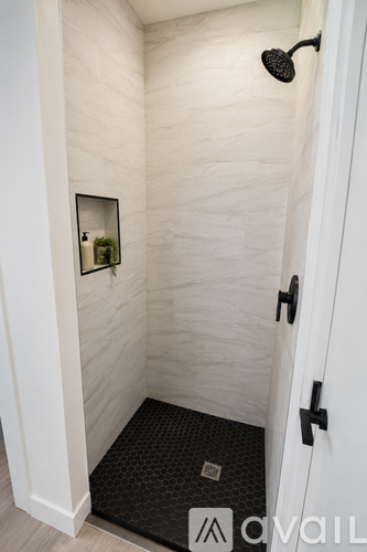 A bathroom with a white door and a mirror on the wall.