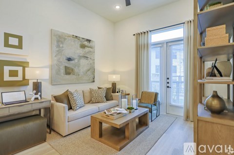 A living room with a couch, a chair, a coffee table, and a painting on the wall.