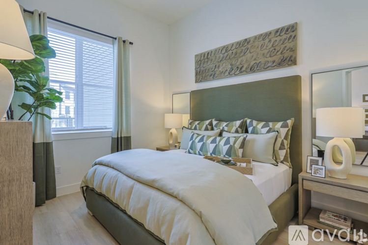 A bedroom with a large bed and a painting on the wall.