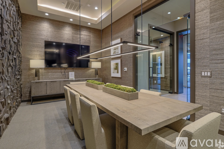 A modern dining room with a long table and chairs.