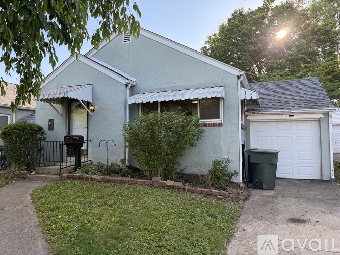 A house with a white garage door and a mailbox on the left.