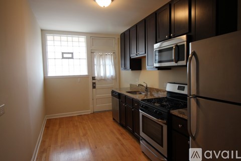 A kitchen with black cabinets and stainless steel appliances.