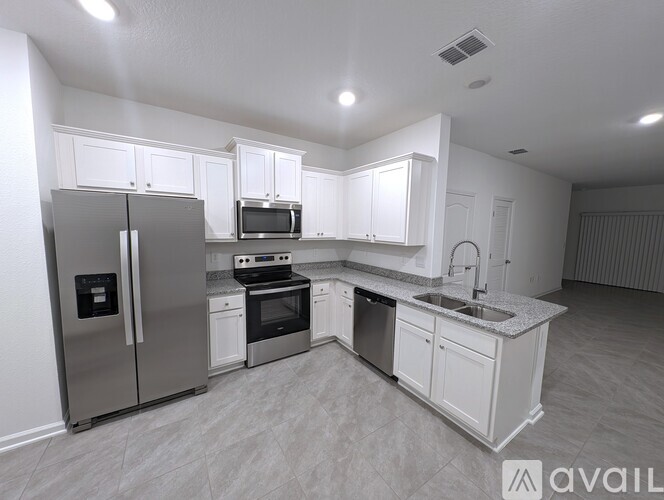 A kitchen with white cabinets and stainless steel appliances.