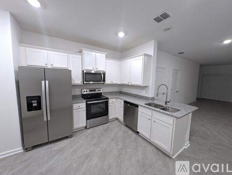A kitchen with white cabinets and stainless steel appliances.