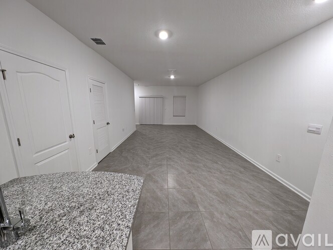 A spacious room with a granite countertop and tile flooring.