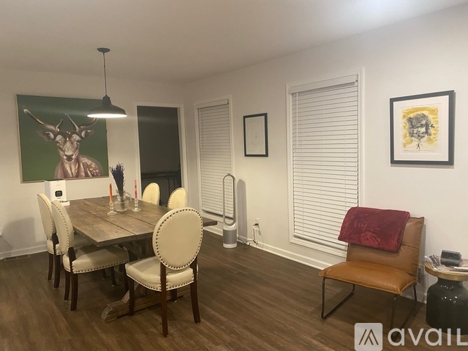 A dining room with a wooden table and chairs.