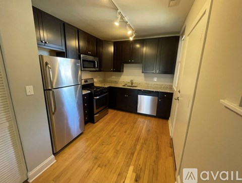 A kitchen with wooden floors and stainless steel appliances.