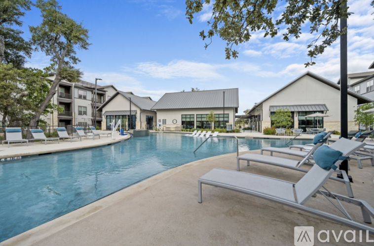 A pool with sun loungers and a building in the background.