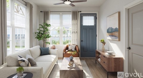 A living room with a white couch, a wooden coffee table, and a painting on the wall.