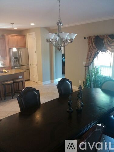 A dining room with a black table and chairs.
