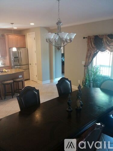 A dining room with a black table and chairs.