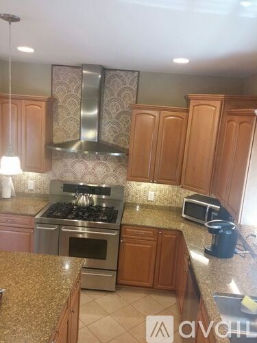 A kitchen with wooden cabinets and granite countertops.