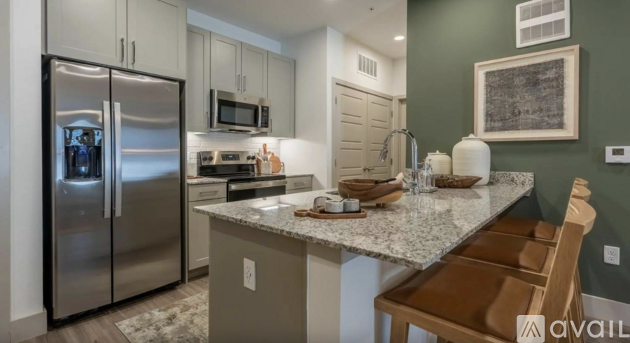 A kitchen with a granite countertop and stainless steel appliances.